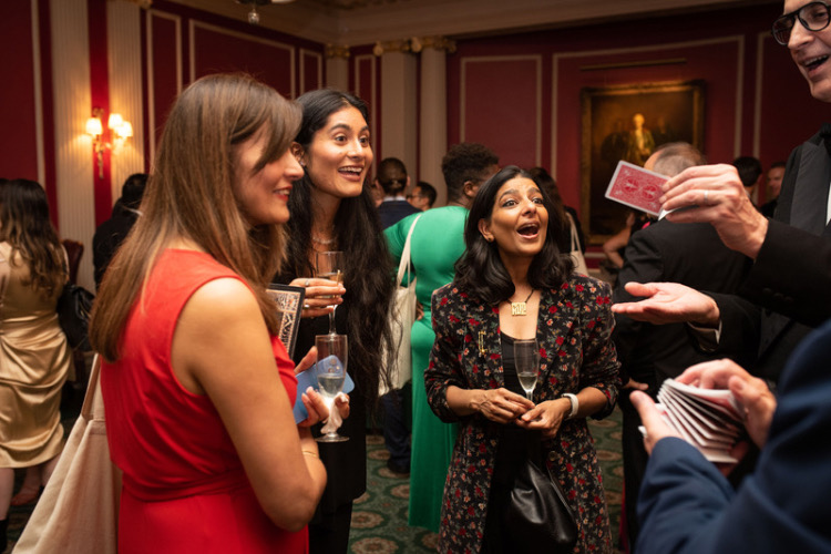 Guests at the Caledonian Club in London enjoying tricks by a professional magician