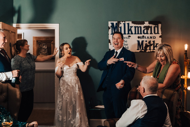 Wedding guests and a bride enjoying magic tricks at Widbrook Grange Cotswolds wedding venue